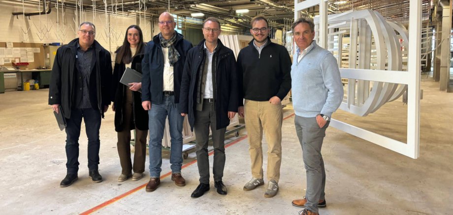 Landrat und Wirtschaftsdezernent Dr. Jens Mischak (dritter von rechts), gemeinsam mit Reiner Dräger (von rechts), zuständig für den Vertrieb bei FR Frame Fenstersysteme, dem geschäftsführenden Gesellschafter Fabian Dräger, dem Bürgermeister von Wartenberg, Dr. Olaf Dahlmann, sowie Kathrin Janisch von der Wirtschaftsförderung und Jens Pietsch, vom Arbeitgeberservice der KVA – Kommunales Jobcenter des Vogelsbergkreises, beim Rundgang durch die Produktion.
