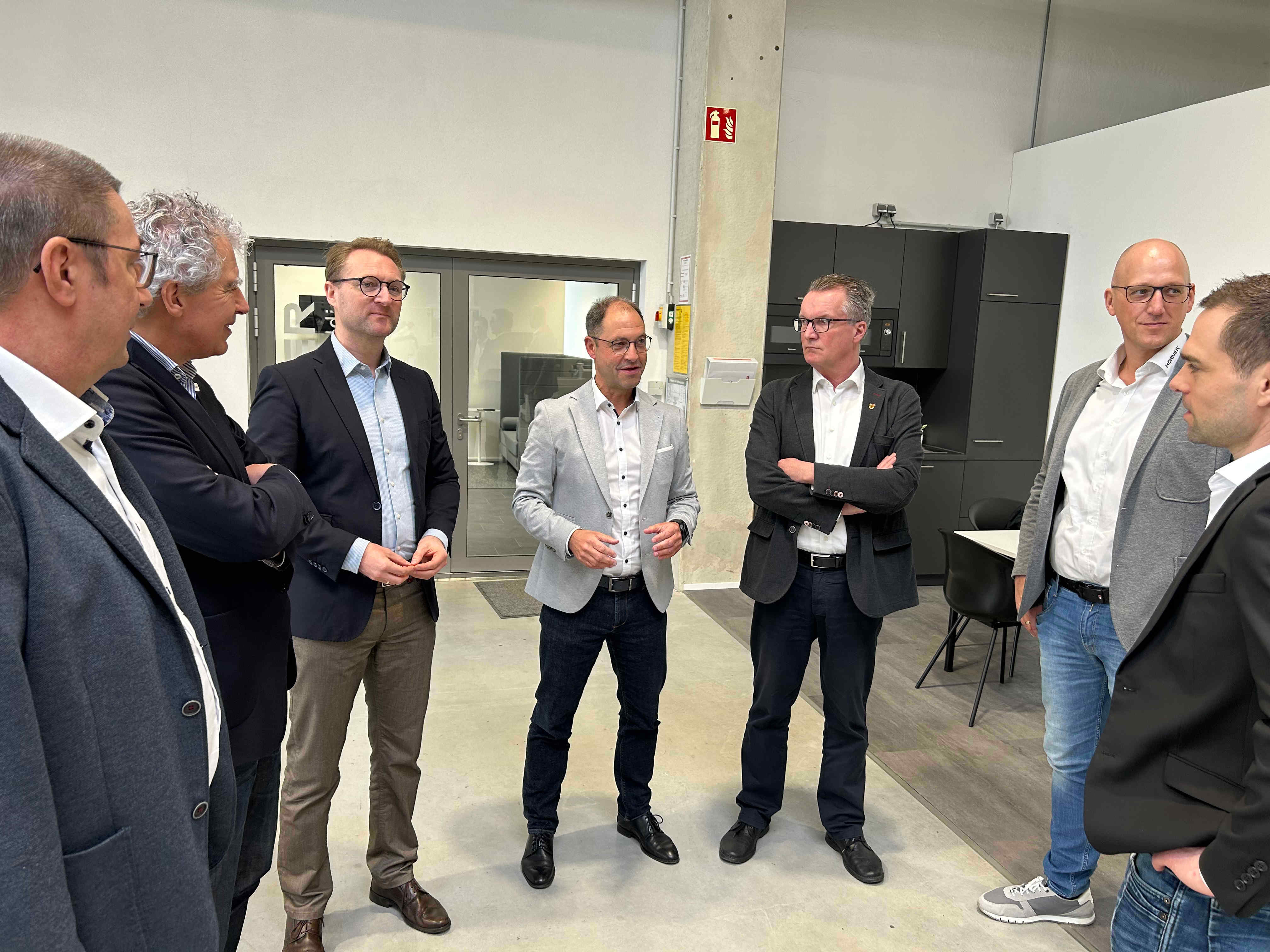 Geschäftsführer Michael Lenz (Mitte) erläutert dem Ersten Kreisbeigeordneten Dr. Jens Mischak (Dritter von links) sowie Harald Raschel von Arbeitgeberservice, Lorenz Kock von der Wirtschaftsförderung und Mückes Bürgermeister Andreas Sommer (von links) gemeinsam mit Dr. Florian Kraus und Ingo Scholz (von rechts, beide von Hürner Schweißtechnik), die Produkte und die Arbeit von Hürner Schweißtechnik. 