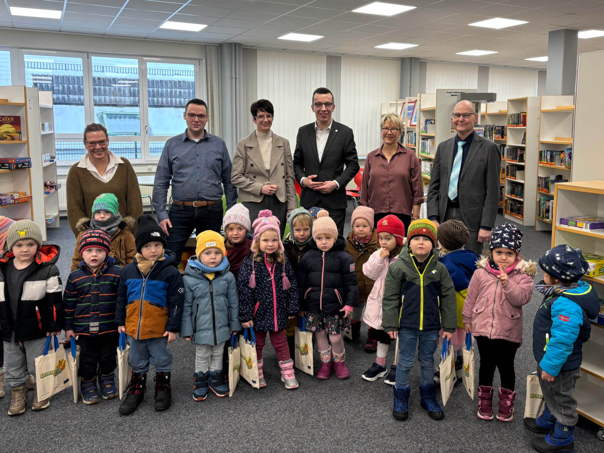 Lesestarter-Sets übergeben: Patrick Krug (hinten, dritter von rechts), Erster Kreisbeigeordneter und Schuldezernent, gemeinsam mit Simke Ried (hinten, dritte von links), Bürgermeisterin der Stadt Homberg, Schulleiter Carsten Röhrscheid (hinten, von rechts), Bibliothekarin Ariana Jende, Matthias Röse, Leiter des Amts für Schulische Bildung und Betreuung, und Antje Reinmuth-Kaut, Schulleiterin der Pestalozzi-Förderschule, gemeinsam mit den Homberger Kita-Kindern.