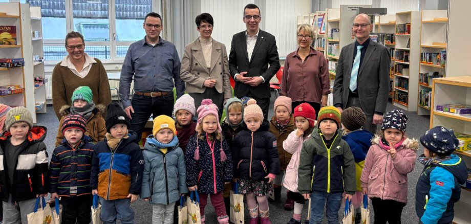 Lesestarter-Sets übergeben: Patrick Krug (hinten, dritter von rechts), Erster Kreisbeigeordneter und Schuldezernent, gemeinsam mit Simke Ried (hinten, dritte von links), Bürgermeisterin der Stadt Homberg, Schulleiter Carsten Röhrscheid (hinten, von rechts), Bibliothekarin Ariana Jende, Matthias Röse, Leiter des Amts für Schulische Bildung und Betreuung, und Antje Reinmuth-Kaut, Schulleiterin der Pestalozzi-Förderschule, gemeinsam mit den Homberger Kita-Kindern.