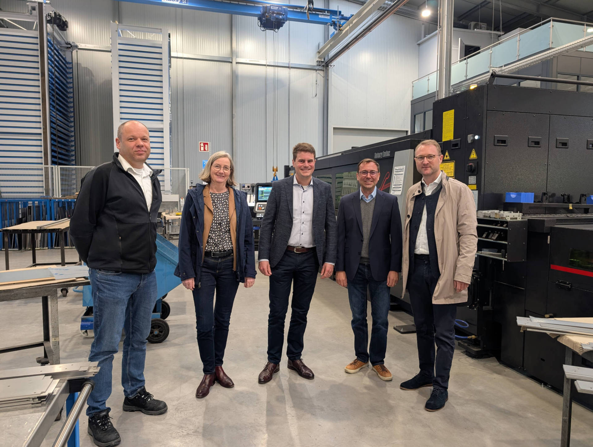 Landrat und Wirtschaftsdezernent Dr. Jens Mischak (von rechts) mit den Geschäftsführern Alexander und Markus Tacke, Andrea Ortstadt von der Wirtschaftsförderung des Vogelsbergkreises, und Marcel Selle, Werksleiter am Produktionsstandort, in der 2023 in Betrieb gegangenen Halle. Mit ihr haben sich zusätzliche Möglichkeiten in der Metallverarbeitung eröffnet.