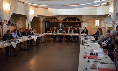 Jens Deutschendorf (stehend), Staatssekretär im Hessischen Ministerium für Wirtschaft, Energie, Verkehr und Wohnen, bei seinem Grußwort flankiert von Jürgen Richter (von links), Referatsleiter Straßenbau im Hessischen Ministerium für Wirtschaft, Energie, Verkehr und Wohnen, Heiko Durth, Präsident von Hessen Mobil, Torsten Bertram, Abteilungsleiter Mobilität und Radverkehr bei Hessen Mobil, und Dr. Rupert Pfeiffer, Abteilungsleiter Betrieb und Verkehr bei Hessen Mobil.