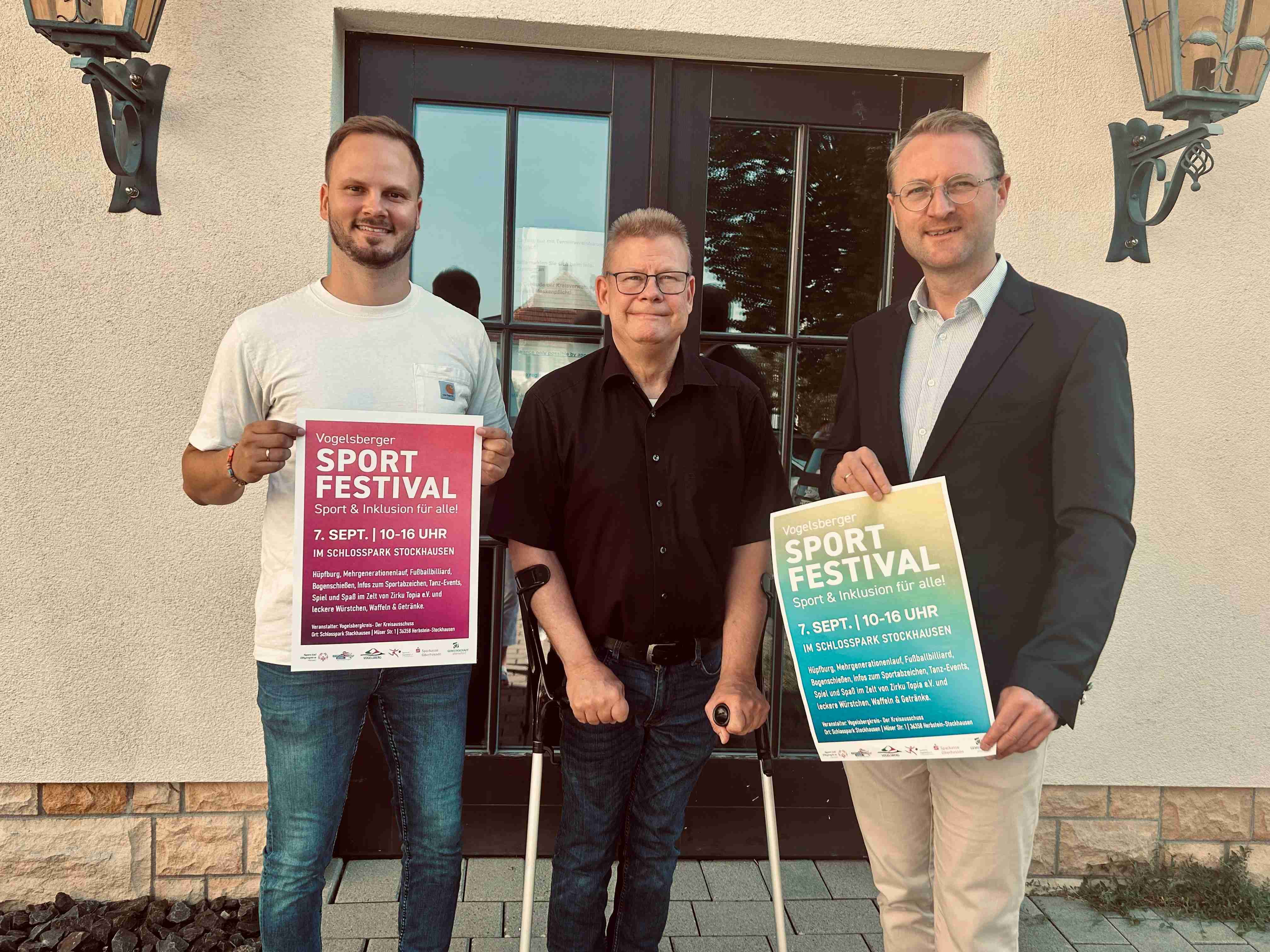 Landrat Dr. Jens Mischak (rechts), präsentiert gemeinsam mit Bewegungskoordinator Dominic Günther (links) und Hans-Jürgen Röhr, Kommunaler Behindertenbeauftragter des Vogelsbergkreises, das Plakat zum Vogelsberger Sportfestival im Schlosspark Stockhausen und ruft die Menschen der Region zum Mitmachen auf.