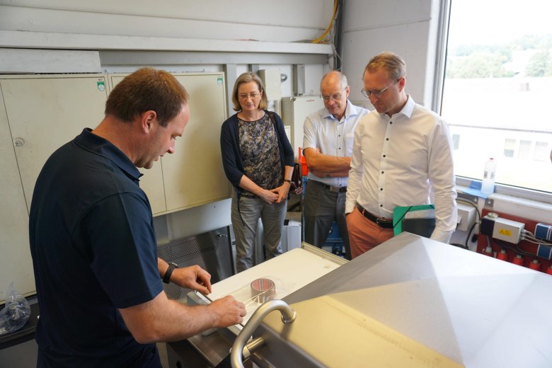 Schauen gespannt auf die Vorführung: Erster Kreisbeigeordneter Dr. Jens Mischak (von rechts), Bernhard Ziegler, Bürgermeister der Stadt Herbstein, und Andrea Ortstadt von der Wirtschaftsförderung schauen Techniker Jan Herchenröder bei der Vorführung zu.