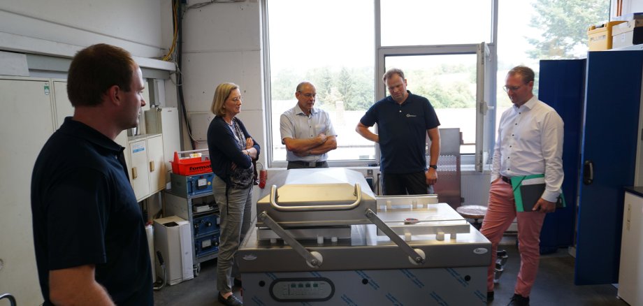 Eine Doppelkammer-Vakuumiermaschine in der Endabnahme: Dr. Jens Mischak (von rechts), Erster Kreisbeigeordneter, Thorsten Schindler, Produktionsleiter bei Boss Vakuum, Bernhard Ziegler, Bürgermeister der Stadt Herbstein, Andrea Ortstadt von der Wirtschaftsförderung und Techniker Jan Herchenröder im Gespräch.