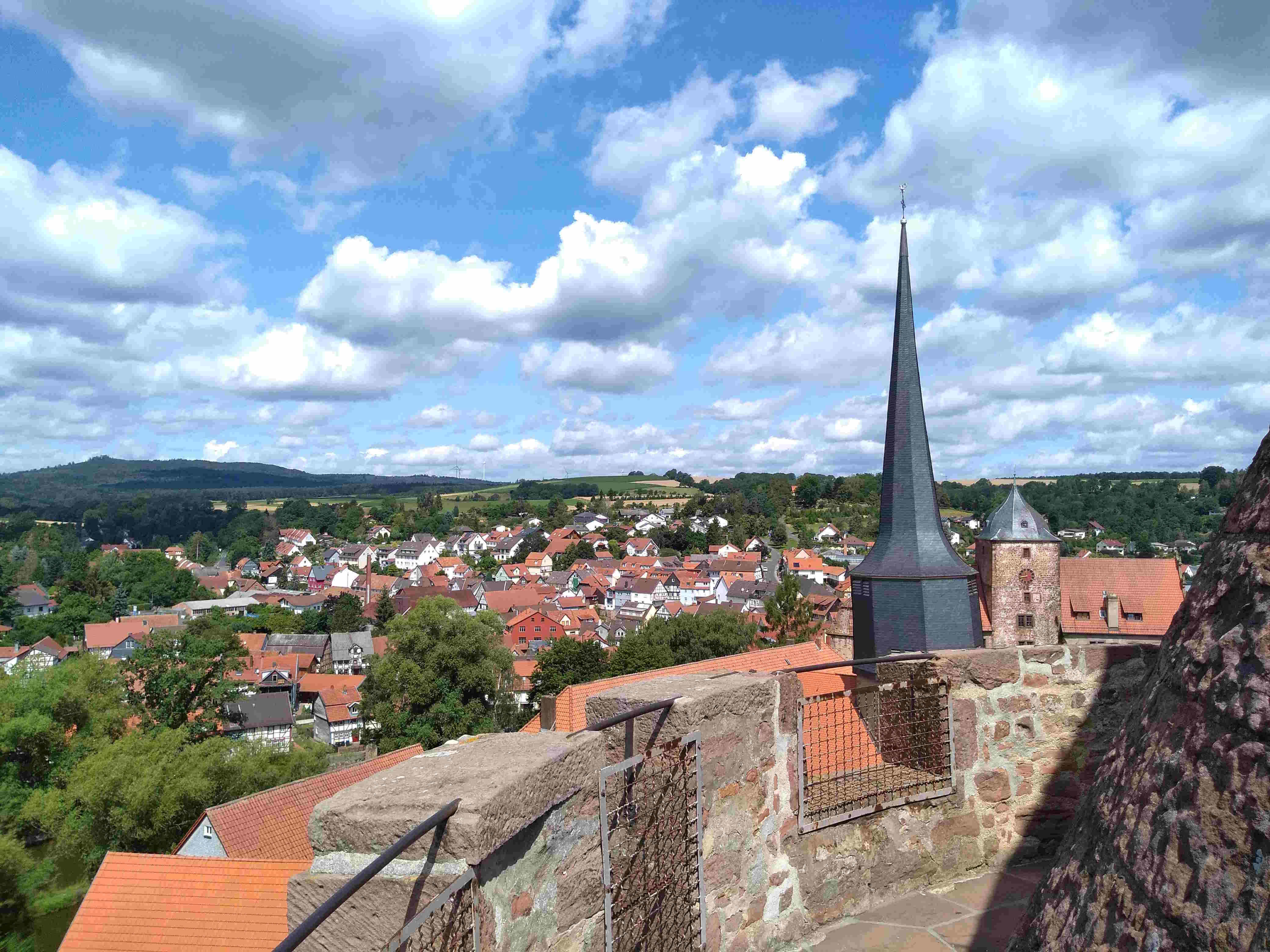 Blick vom Hinterturm über die Dächer von Schlitz. Im Hintergrund sind Felder und Wald zu erkennen. 