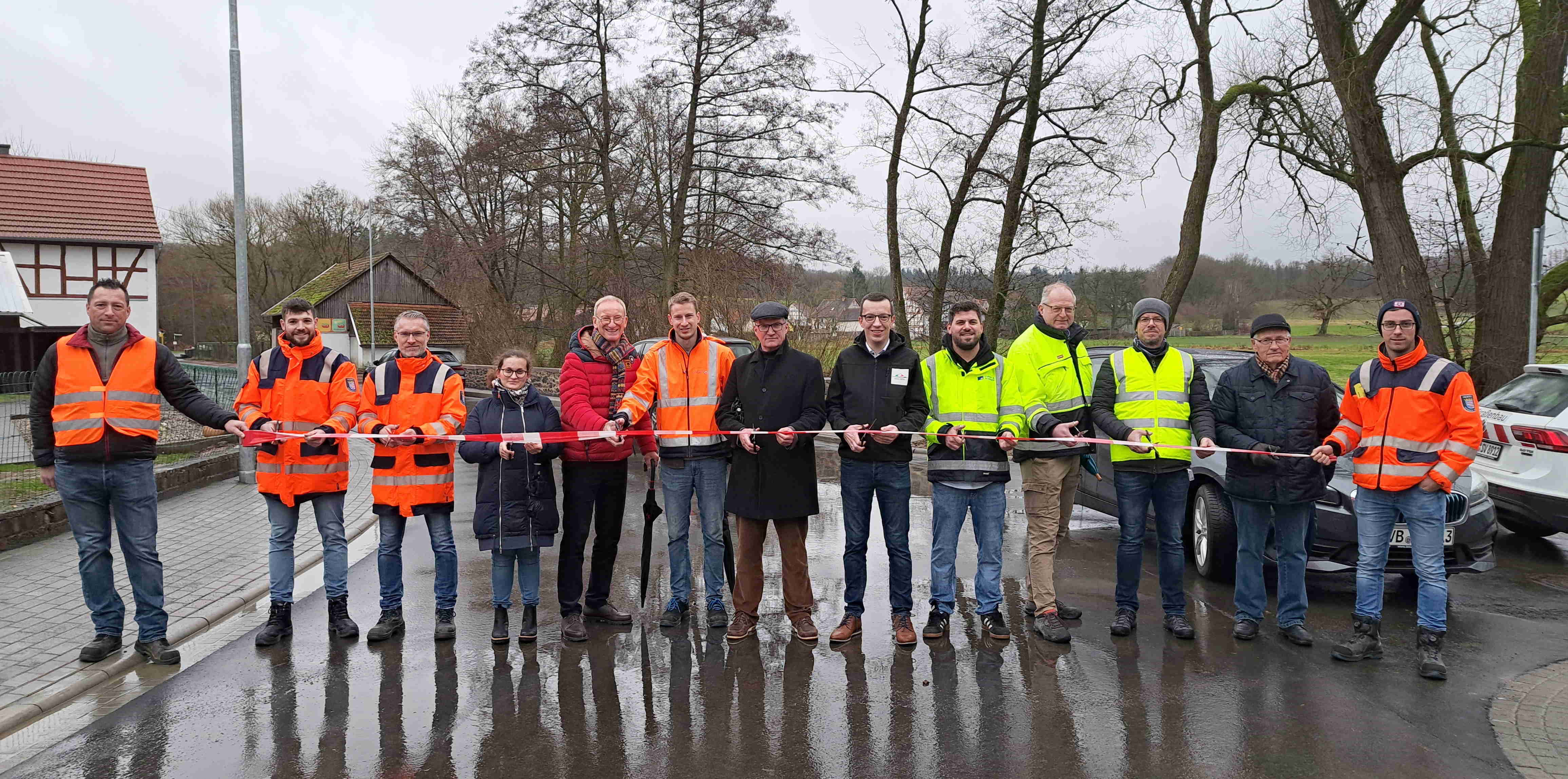 Der Erste Kreisbeigeordnete des Vogelsbergkreises, Patrick Krug (Sechster von rechts), Mückes Bürgermeister Andreas Sommer (Siebter von rechts) und weitere Vertreter von Hessen Mobil, Kreis, Gemeinde und Baufirma beim Moment der offiziellen Verkehrsfreigabe an der K 140 in Ilsdorf.
