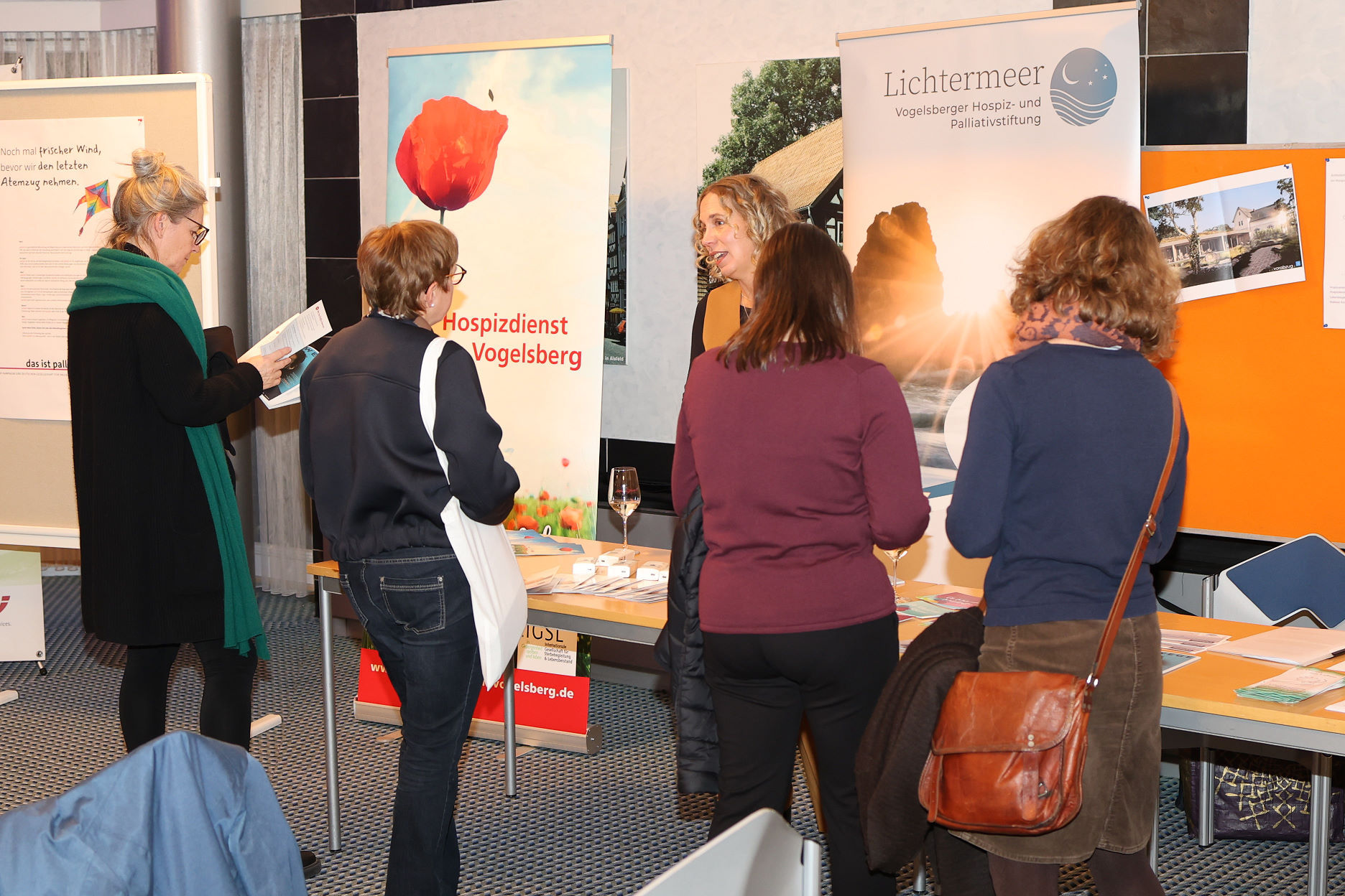 Fünf Frauen sprechen an einem Informationsstand über das Thema Hospiz- und Palliativversorgung.