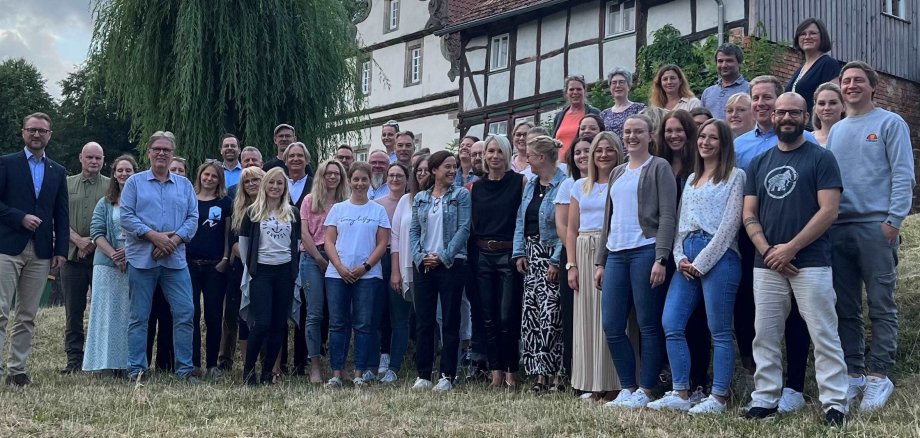 etwa 30 Menschen haben sich zu einem Gruppenbild vor einem Fachwerkhaus aufgestellt