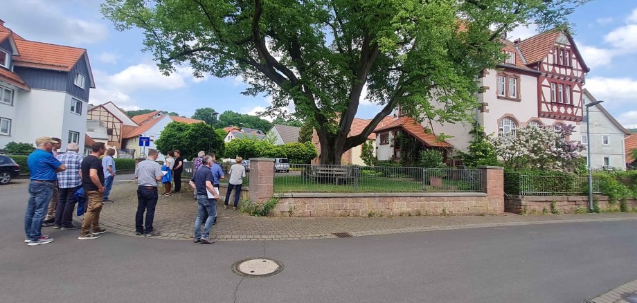 Archivbild von der Jury-Bereisung aus Pfordt. Der Schlitzer Stadtteil nahm beim 37. Wettbewerb als eines von 12 hessischen Dörfern am Landesentscheid teil. Eine Gruppe von Menschen steht an einem Grundstück mit einem imposanten alten Baum im Vorgarten