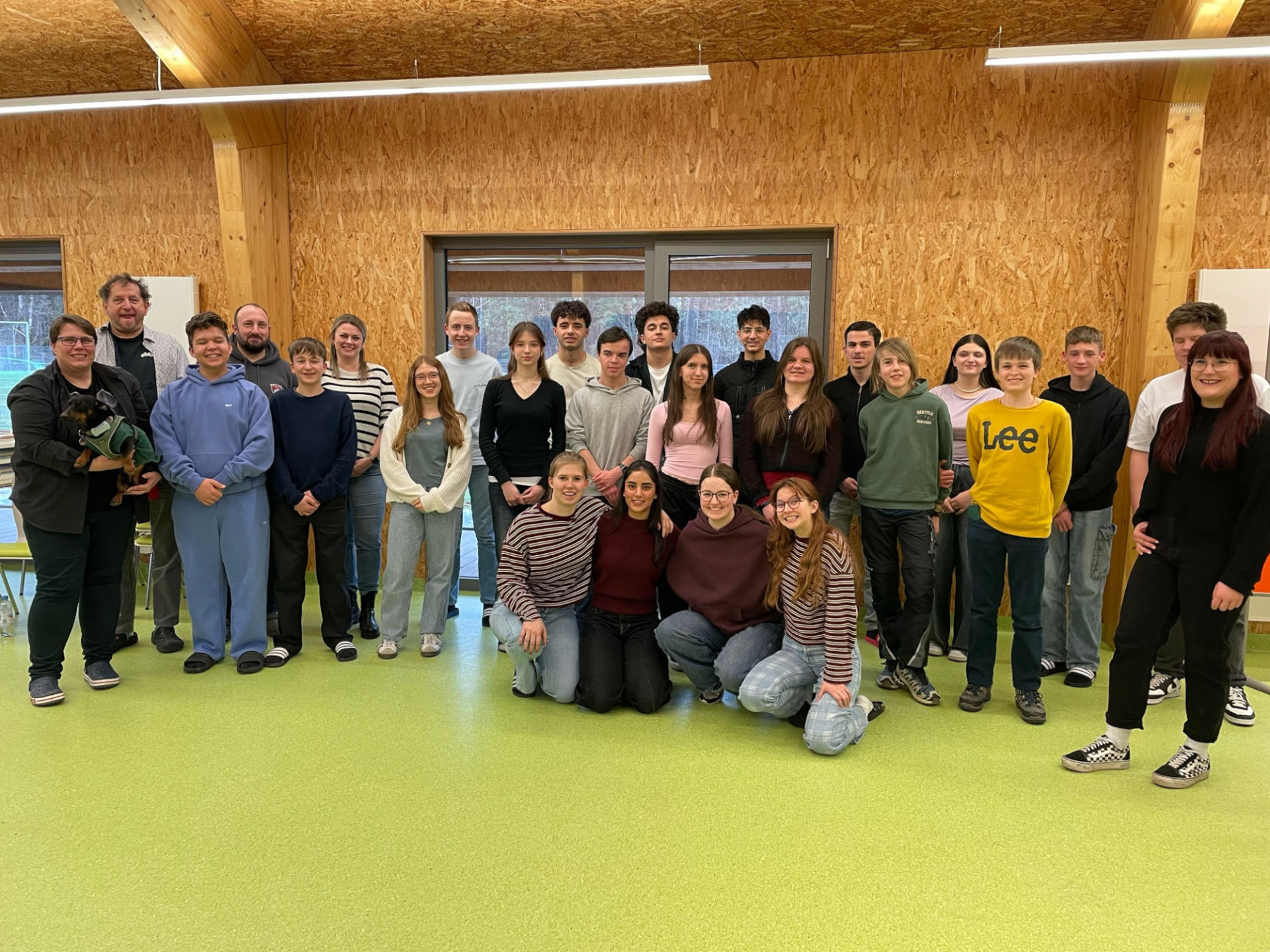 Rund 20 Menschen haben sich in einem Sitzungsraum zu einem Gruppenbild aufgestellt.