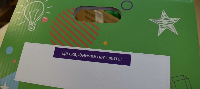 Das Namensschild auf Ukrainisch, dazu ein Deckel um die kleinen Schätze sicher zu verwahren – Auf dem Bild ist das Etikett auf einer grünen Pappkiste zu sehen. 