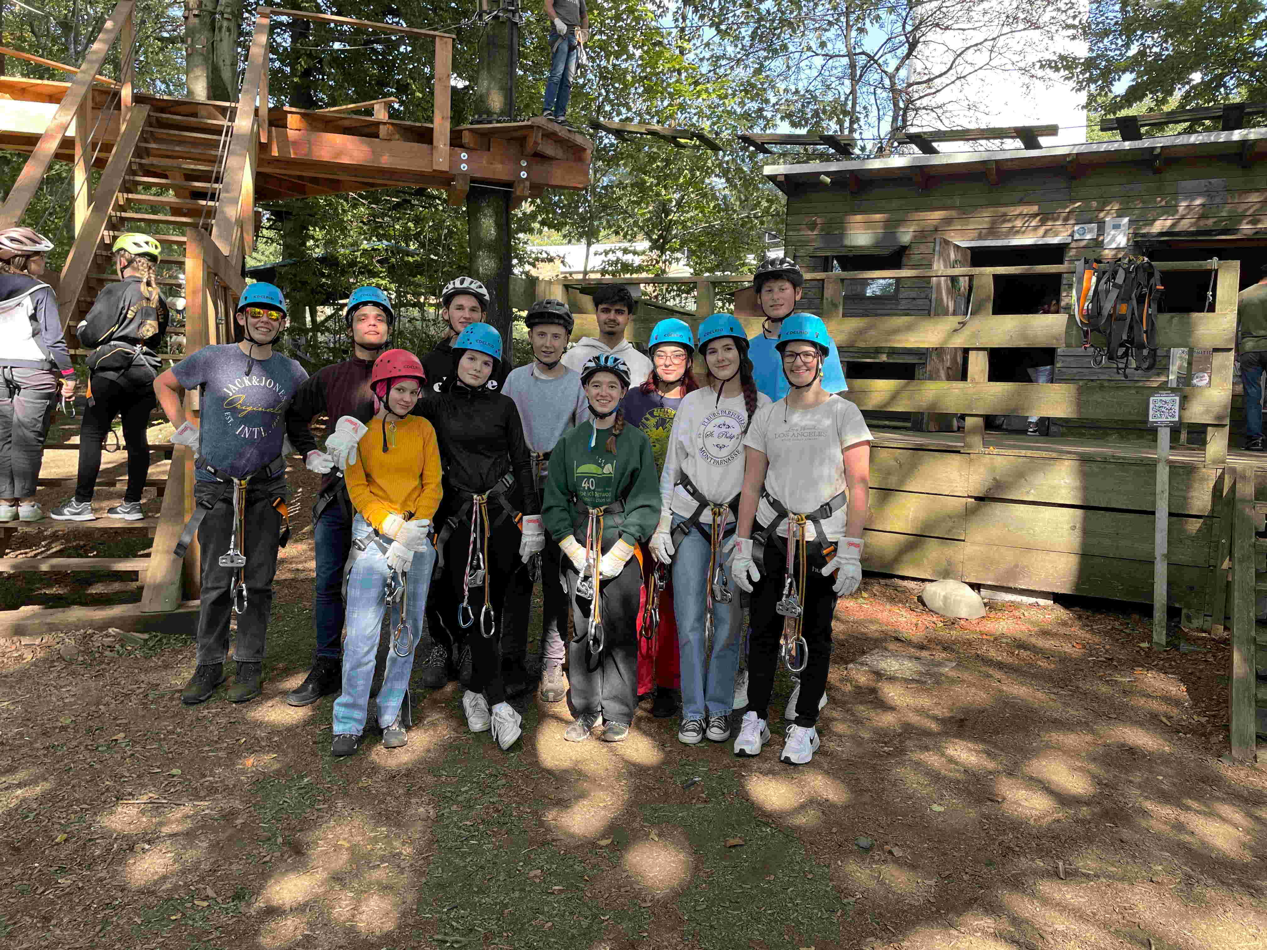 Neben ihrer parlamentarischen Arbeit nutzen die KJP-Mitglieder die freie Zeit im Kletterpark. Sie haben sich in Kletterausrüstung mit Gurten und Helmen zum Gruppenbild aufgestellt