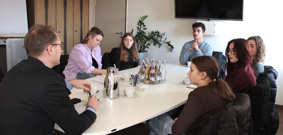 Dr. Jens Mischak im Gespräch Angelina Kuhl vom Jugendamt und den KJP-Abgeordneten Selin Volp, Armin Salavati, Amelie Theis, Johanna Faubel und Esther Arnold (im Uhrzeigersinn). 