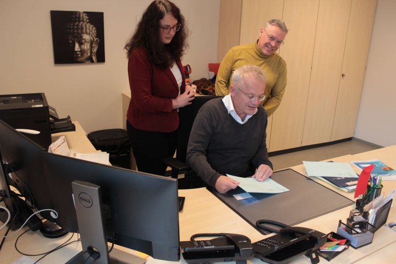 Die Leitung des Vogelsberger Gesundheitsamtes mit Dr. Henrik Reygers (Mitte), Dr. Rüdiger Rau und Jessica Luft. Dr. Reygers sitzt an seinem Schreibtisch, die anderen beiden schauen ihm über die Schultern