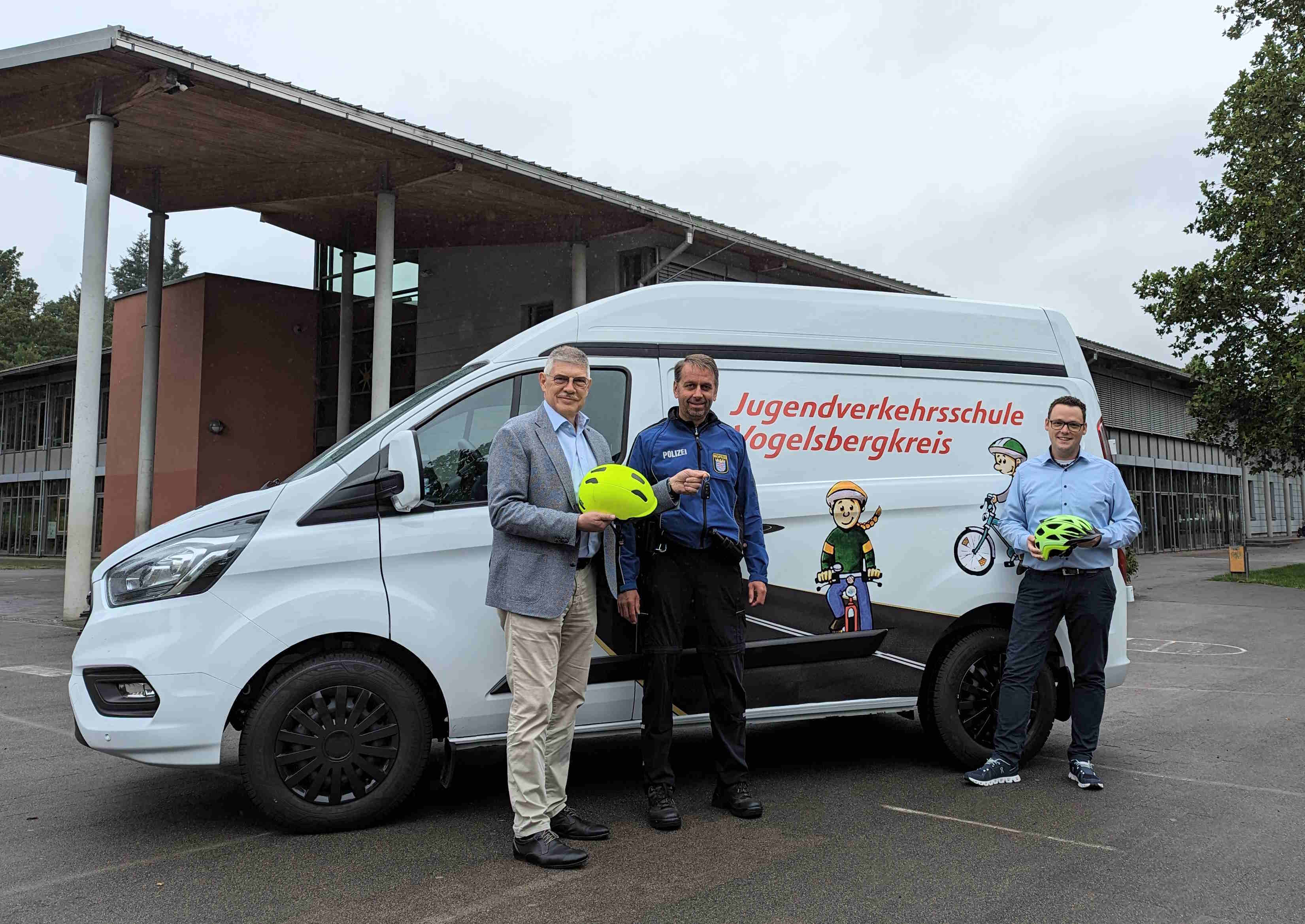 Schlüsselübergabe an der Eichbergschule in Lauterbach: Landrat Manfred Görig (links) und Matthias Röse (rechts), Leiter des Amtes für Schulische Bildung und Betreuung, überreichen Wachpolizist Dirk Boß, Jugendverkehrsschule Vogelsbergkreis, den Schlüssel für das neue Fahrzeug.