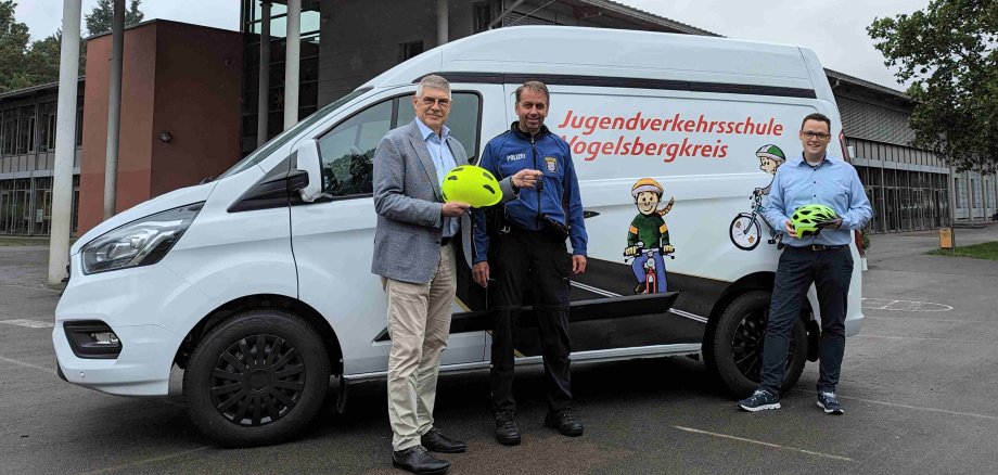 Schlüsselübergabe an der Eichbergschule in Lauterbach: Landrat Manfred Görig (links) und Matthias Röse (rechts), Leiter des Amtes für Schulische Bildung und Betreuung, überreichen Wachpolizist Dirk Boß, Jugendverkehrsschule Vogelsbergkreis, den Schlüssel für das neue Fahrzeug.