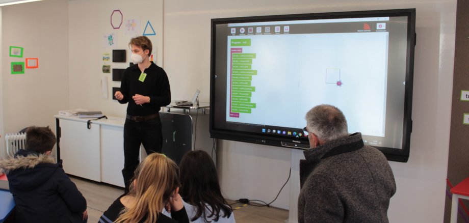 TurtleCoder am Activboard: Nick vom DigitalTruck-Team geht mit den Drittklässlern die Befehle durch, die die Schildkröte später abarbeiten soll. 