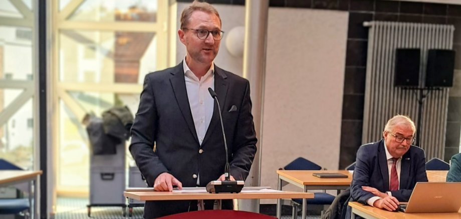 Landrat Dr. Mischak steht an einem Rednerpult.