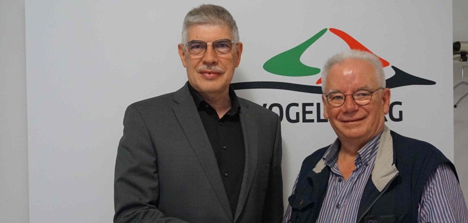Landrat Manfred Görig und Michael Hermann sind auf dem Foto zu sehen. Sie halten gemeinsam eine Urkunde in der Hand