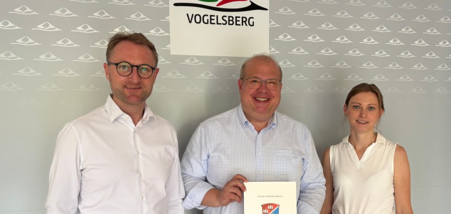 Landrat Dr. Jens Mischak (links) übergibt gemeinsam mit Jana Brittner, Sachgebietsleitung der Dorf- und Regionalentwicklung im Amt für Wirtschaft und den ländlichen Raum, dem Alsfelder Bürgermeister Stephan Paule einen Förderbescheid über 1,2 Millionen Euro für die „Multifunktionshalle für alle“ in Leusel.