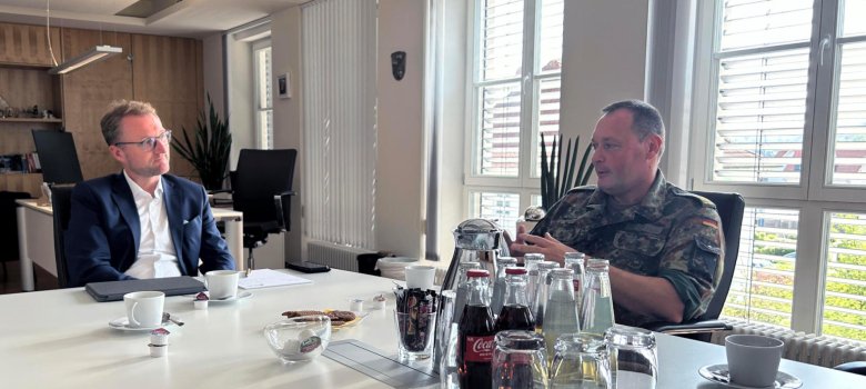 Landrat Dr. Mischak und Brigadegeneral Radmann im GEspräch an einem Tisch