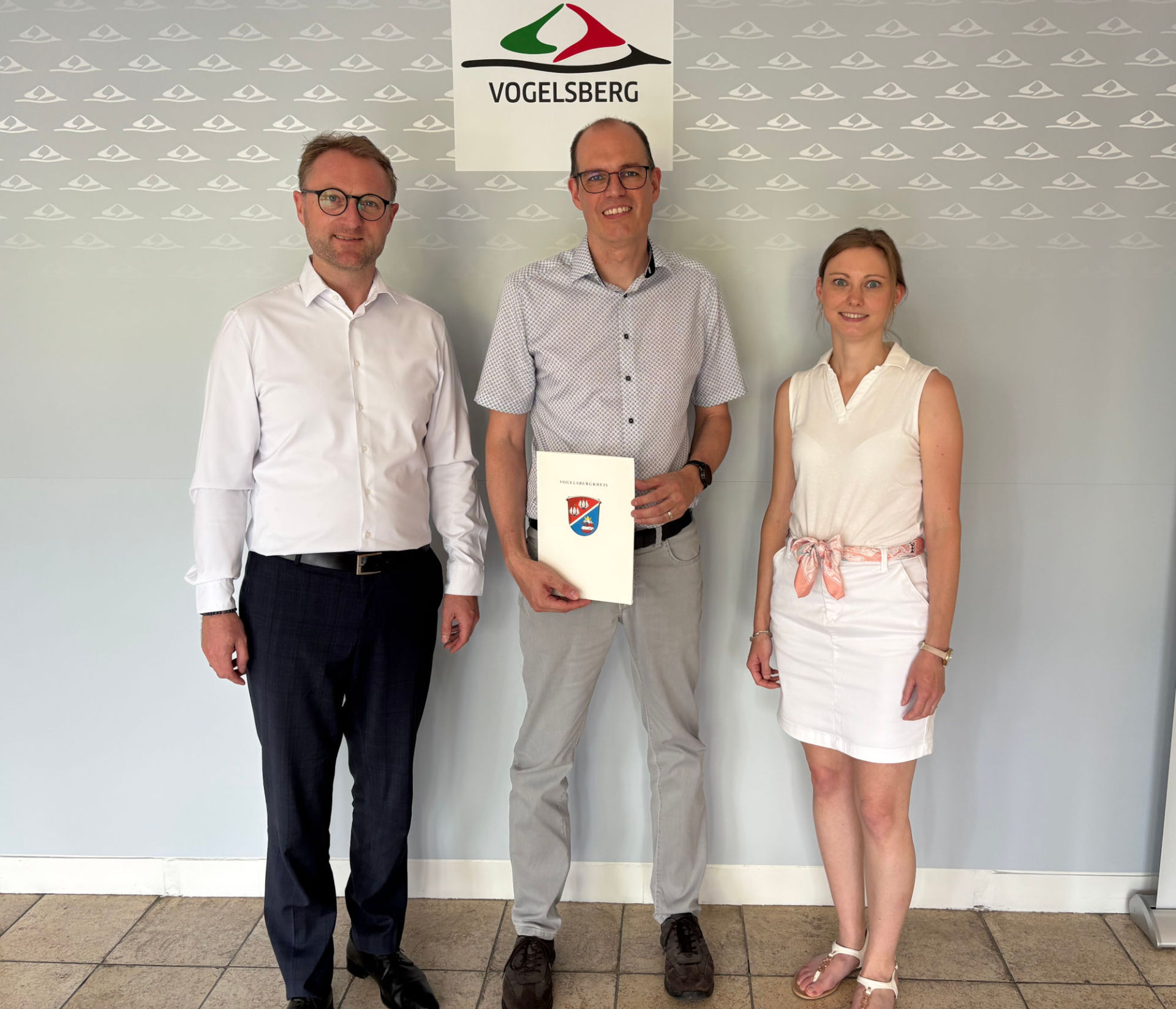 Landrat Dr. Jens Mischak (links) übergibt gemeinsam mit Jana Brittner, Sachgebietsleitung der Dorf- und Regionalentwicklung im Amt für Wirtschaft und den ländlichen Raum, einen Förderbescheid für Maßnahmen am Torbogenhaus und dem DGH Radmühl an Freiensteinaus Bürgermeister Sascha Spielberger.