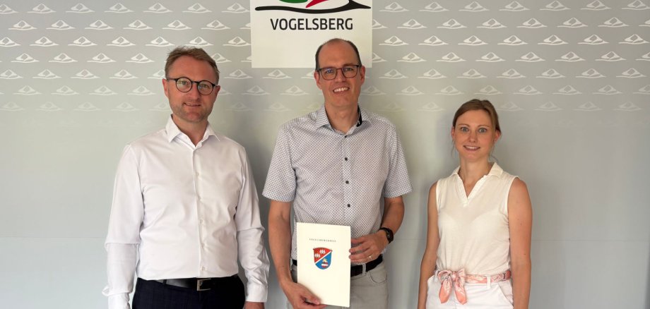 Landrat Dr. Jens Mischak (links) übergibt gemeinsam mit Jana Brittner, Sachgebietsleitung der Dorf- und Regionalentwicklung im Amt für Wirtschaft und den ländlichen Raum, einen Förderbescheid für Maßnahmen am Torbogenhaus und dem DGH Radmühl an Freiensteinaus Bürgermeister Sascha Spielberger.