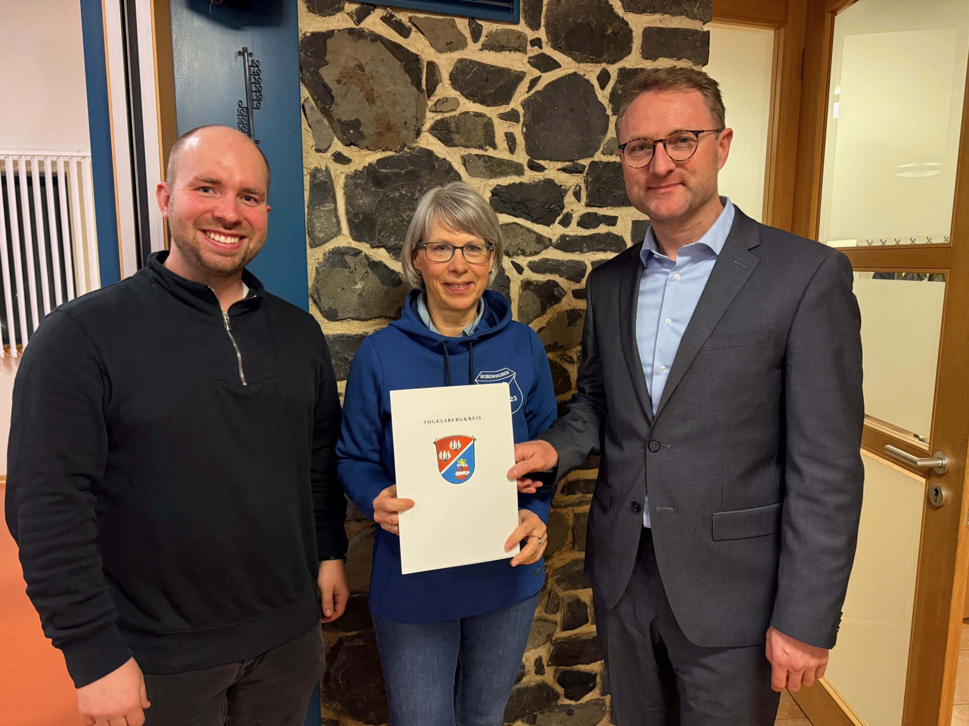 Landrat Dr. Jens Mischak (rechts) übergibt Vertretern vom SV Germania 1923 Bobenhausen II den Zuwendungsbescheid. Rund 5.000 Euro unterstützen die Sanierung des Sportheimdaches.