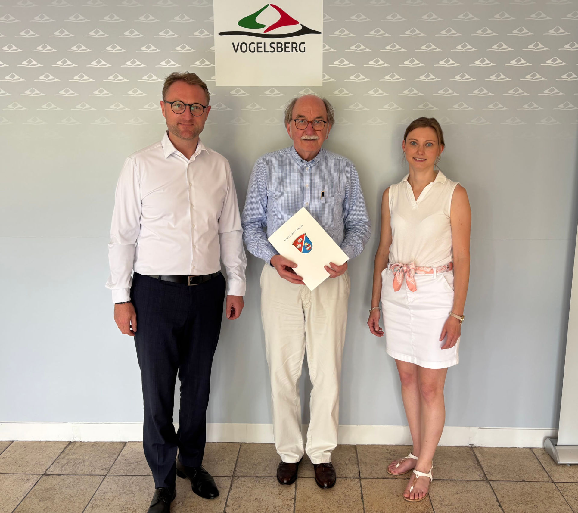 Gemeinsam mit Jana Brittner, Sachgebietsleitung der Dorf- und Regionalentwicklung im Amt für Wirtschaft und den ländlichen Raum, übergibt mit Landrat Dr. Jens Mischak (links) den Förderbescheid für die Umgestaltung des ehemaligen Schwimmbadgebäudes in Maar an den Bürgermeister der Stadt Lauterbach, Rainer-Hans Vollmöller.