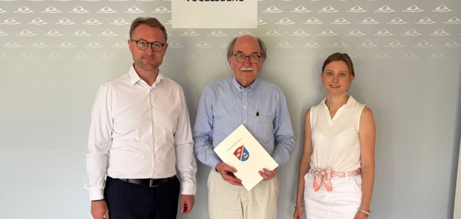 Gemeinsam mit Jana Brittner, Sachgebietsleitung der Dorf- und Regionalentwicklung im Amt für Wirtschaft und den ländlichen Raum, übergibt mit Landrat Dr. Jens Mischak (links) den Förderbescheid für die Umgestaltung des ehemaligen Schwimmbadgebäudes in Maar an den Bürgermeister der Stadt Lauterbach, Rainer-Hans Vollmöller.