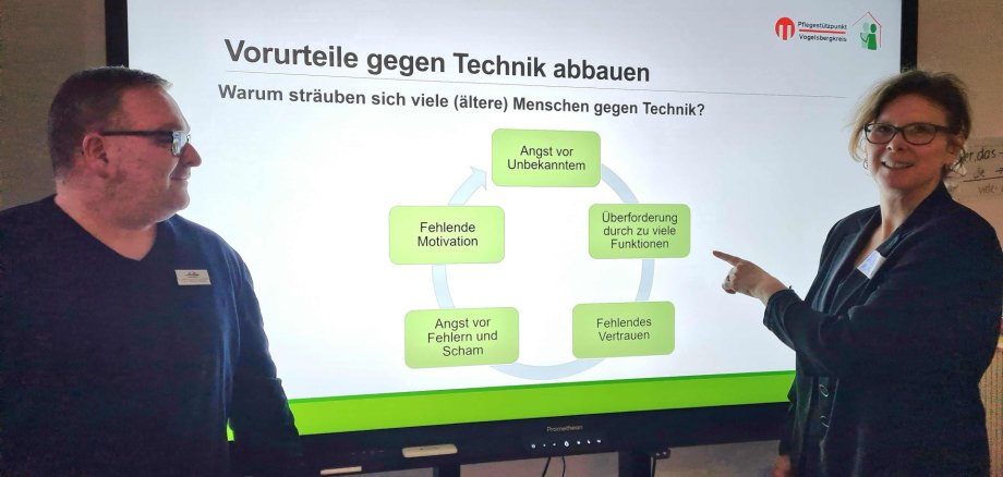 Sonja Reichel vom Pflegestützpunkt und Michael Merschrod von der Fachstelle „Prävention im Alter – PrimA“ stellen gemeinsam Technik vor, die das Leben im Alter erleichtert. die beiden stehen vor einem großen Bildschirm und informieren zum Thema.