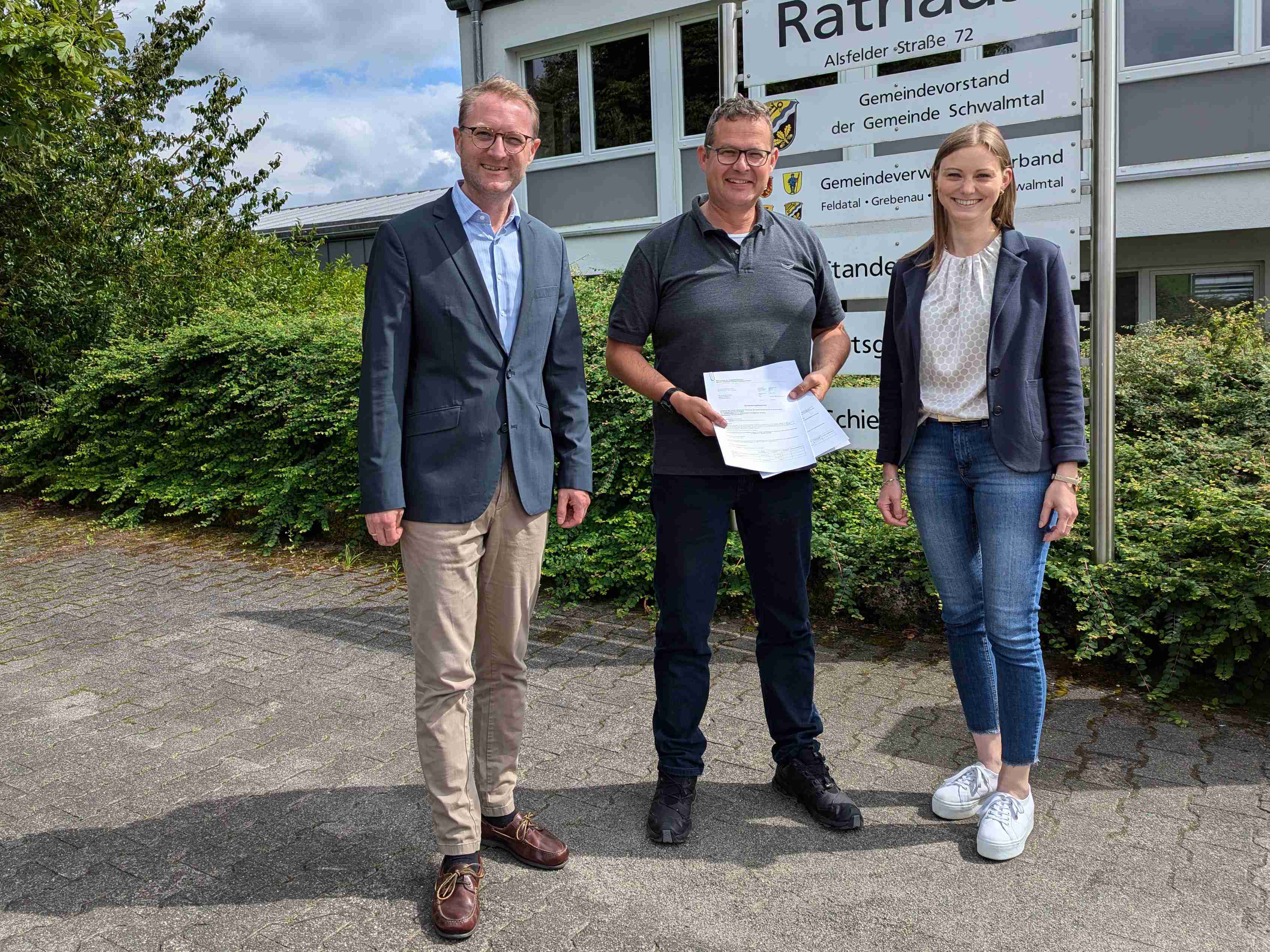 Nun können die Maßnahmen starten, die Zuwendungsbescheide liegen vor: Landrat Dr. Jens Mischak (links) überreicht sie gemeinsam mit Jana Brittner, Sachgebietsleitung der Dorf- und Regionalentwicklung im Amt für Wirtschaft und den ländlichen Raum, an Schwalmtals Bürgermeister Timo Georg.