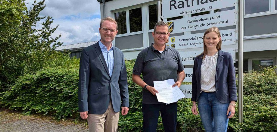 Nun können die Maßnahmen starten, die Zuwendungsbescheide liegen vor: Landrat Dr. Jens Mischak (links) überreicht sie gemeinsam mit Jana Brittner, Sachgebietsleitung der Dorf- und Regionalentwicklung im Amt für Wirtschaft und den ländlichen Raum, an Schwalmtals Bürgermeister Timo Georg.