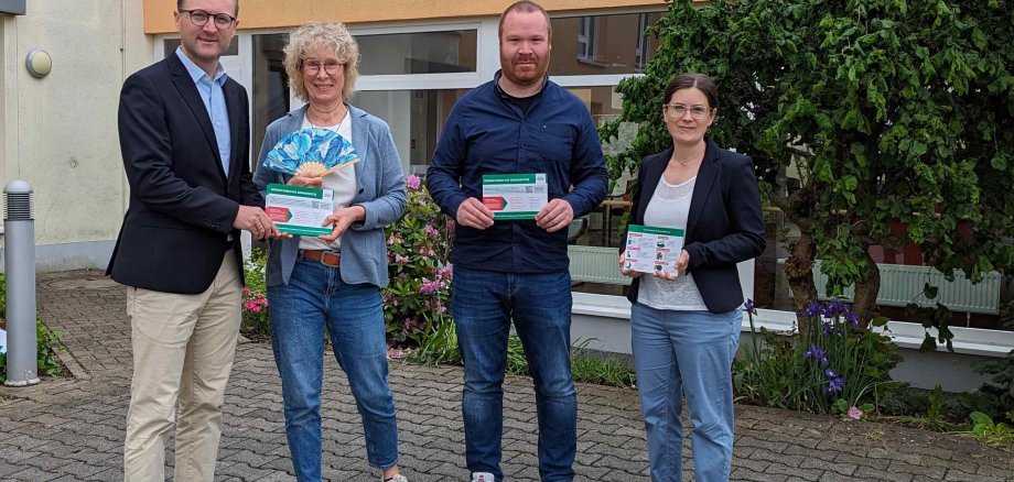 Gesundheitsdezernent Dr. Mischak überreicht bei einem Vor-Ort-Termin im AWO Sozialzentrum Lauterbach nfoflyer an Einrichtungsleiterin Sylvia Motz-Sattler und Pflegedienstleiter Christoph von Keitz. Sie stehen vor gemeinsam mit Carina Diezemann vor dem Gebäude.