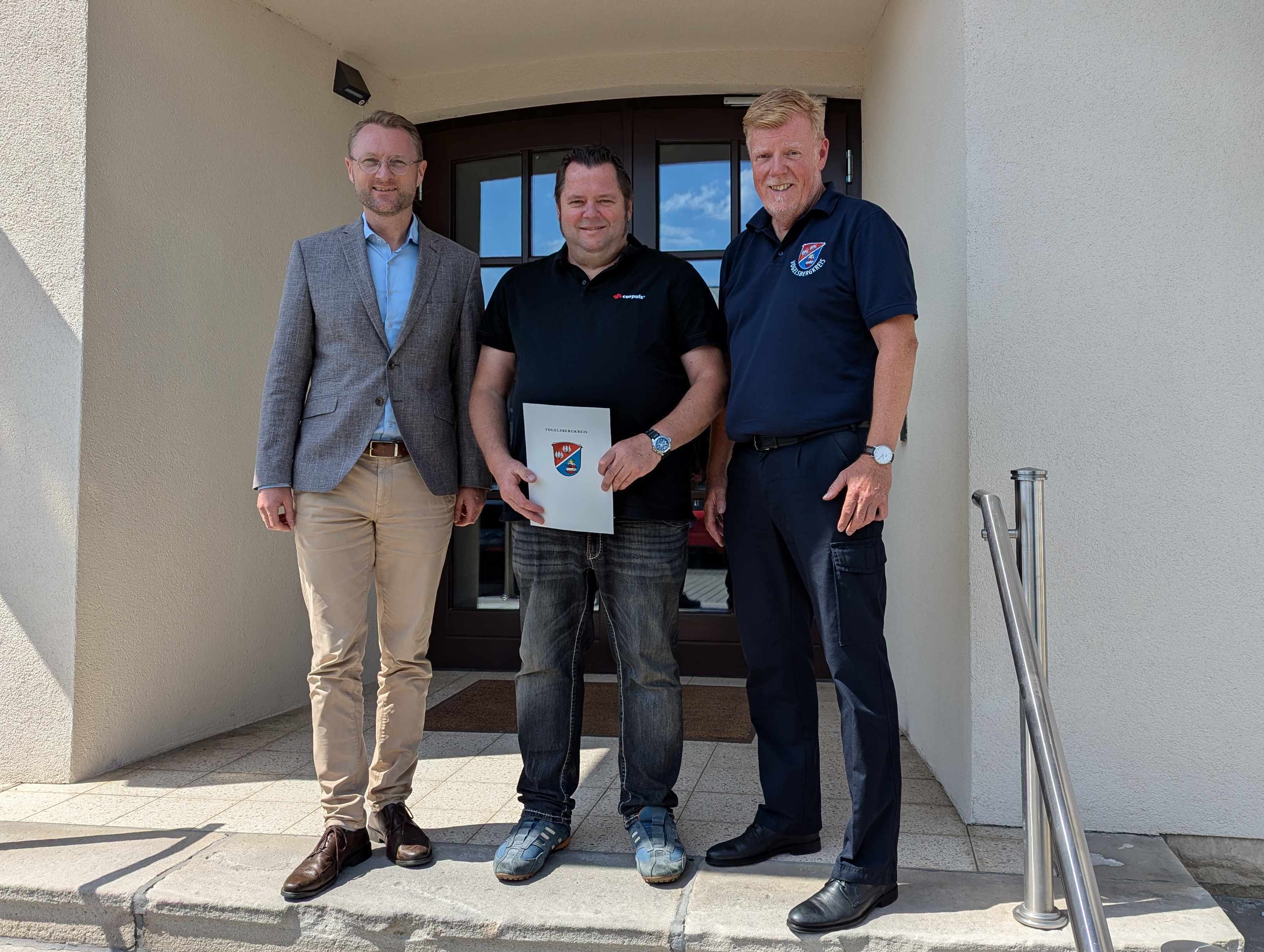 Landrat Dr. Jens Mischak (von links) ernennt Florian Seel zum Leitenden Notarzt für den Vogelsbergkreis. Jürgen Schad, stellvertretender Leiter des Amtes für Gefahrenabwehr, freut sich auf die Zusammenarbeit mit dem erfahrenen Notfall-Mediziner.