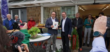 Dr. Jens Mischak (rechts), Erster Kreisbeigeordneter, übergibt den Förderbescheid über 17.500 Euro an Werner Müller, Aufsichtsratsvorsitzender der Genossenschaft.
