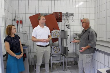 Dr. Jens Mischak (Mitte) schaut sich während seines Besuchs gemeinsam mit Anja Püchner, Leiterin des Amtes für Wirtschaft und den ländlichen Raum, auch das Schlachthaus auf dem Otterbacherhof an.