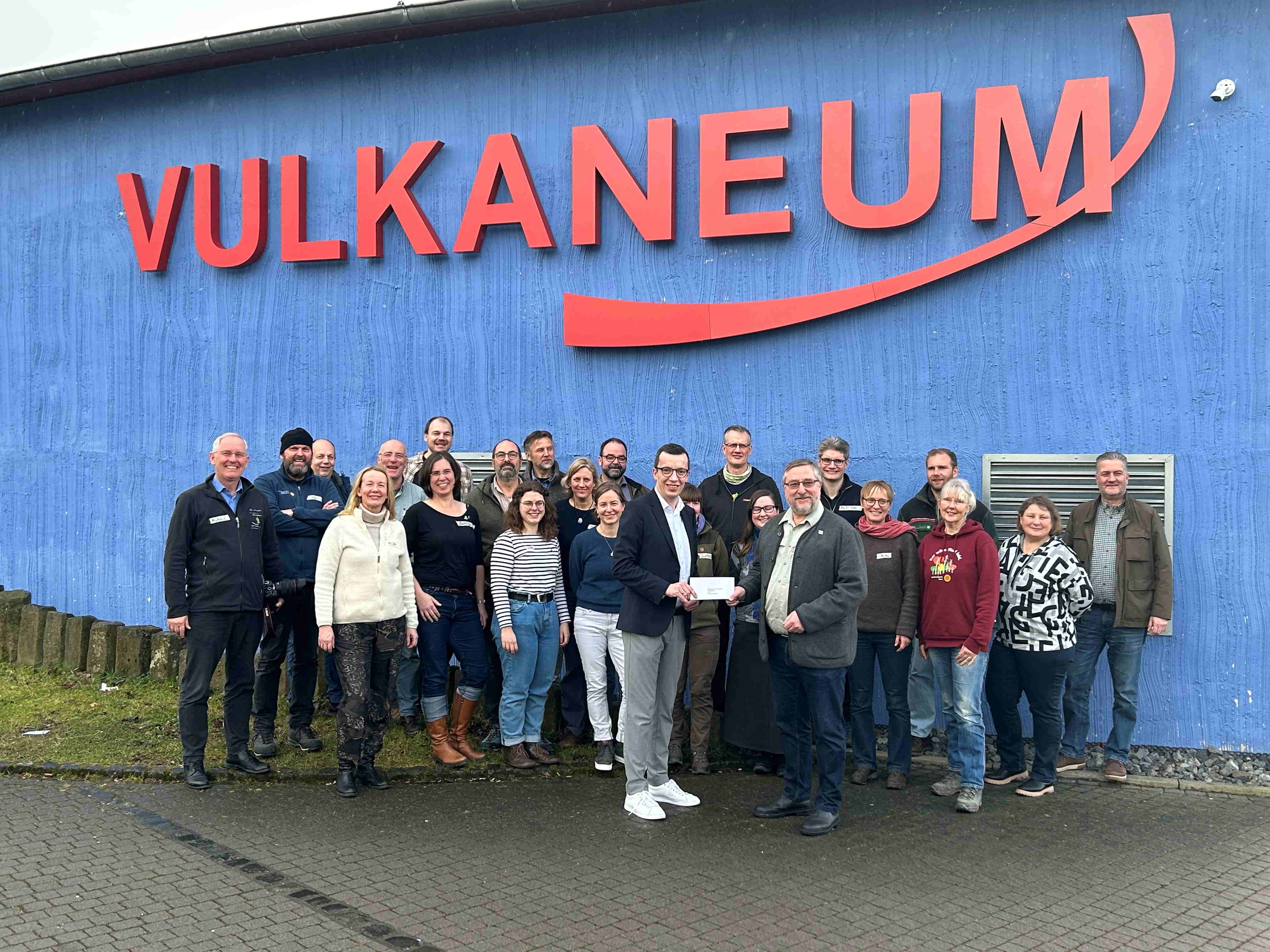 Gruppenbild vor dem Vulkaneum in Schotten. Rund 20 Personen haben sich davor aufgestellt