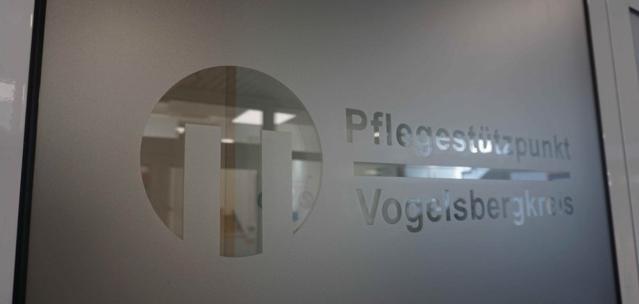 Eine Folienbeklebung auf einer Glastür zeigt das Logo des Pflegestützpunkts Vogelsberg.