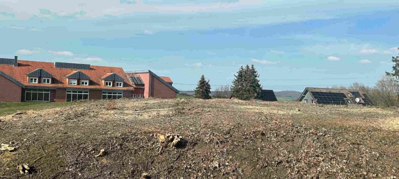 Auf diesem Gelände zwischen dem alten Krankenhaus und dem MVZ in der ehemaligen Krankenpflegeschule wird der Neubau entstehen. Zu sehen ist eine gerodete Fläche mit einem Gebäude im Hintergrund.