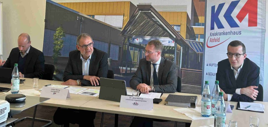 Landrat Dr. Jens Mischak, Erster Kreisbeigeordneter Patrick Krug, Krankenhaus-Geschäftsführer Volker Röhrig und der Assistent der Geschäftsführung, Jan Klassert, stellen die Pläne des Neubaus vor.