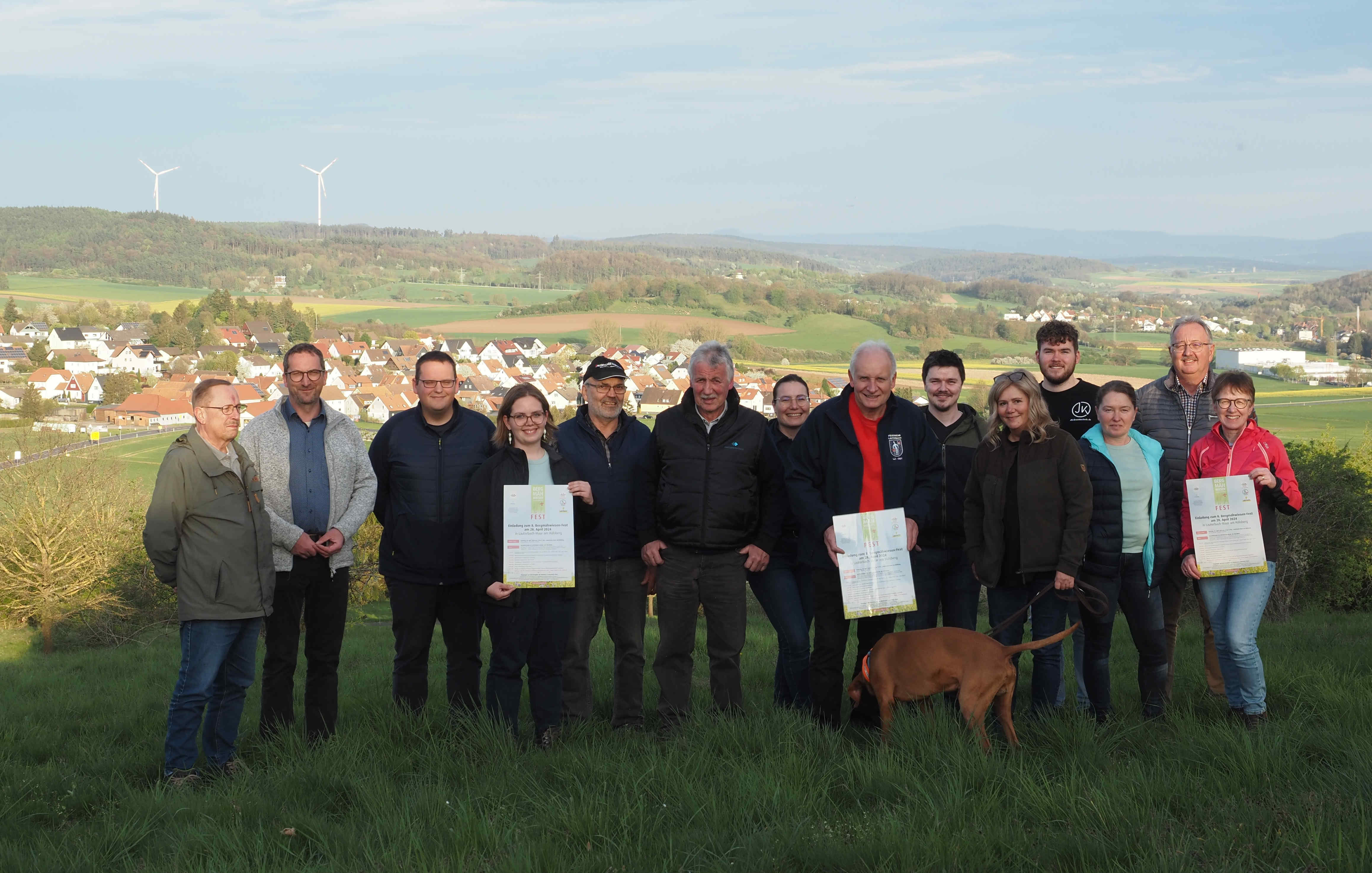Ronny Mohr (Zweiter von rechts), Kommissarischer Leiter des Amtes für Wirtschaft und den ländlichen Raum des Vogelsbergkreises, und Johannes Euler (Sechster von rechts), Projektleiter Naturschutzgroßprojekt Vogelsberg, und Silke Grünewald (Achte von rechts), Stadtverwaltung Lauterbach, gemeinsam mit Vertreterinnen und Vertretern der teilnehmenden Vereine und Organisationen am „Hälsberg“ mit Blick auf Maar und Lauterbach.