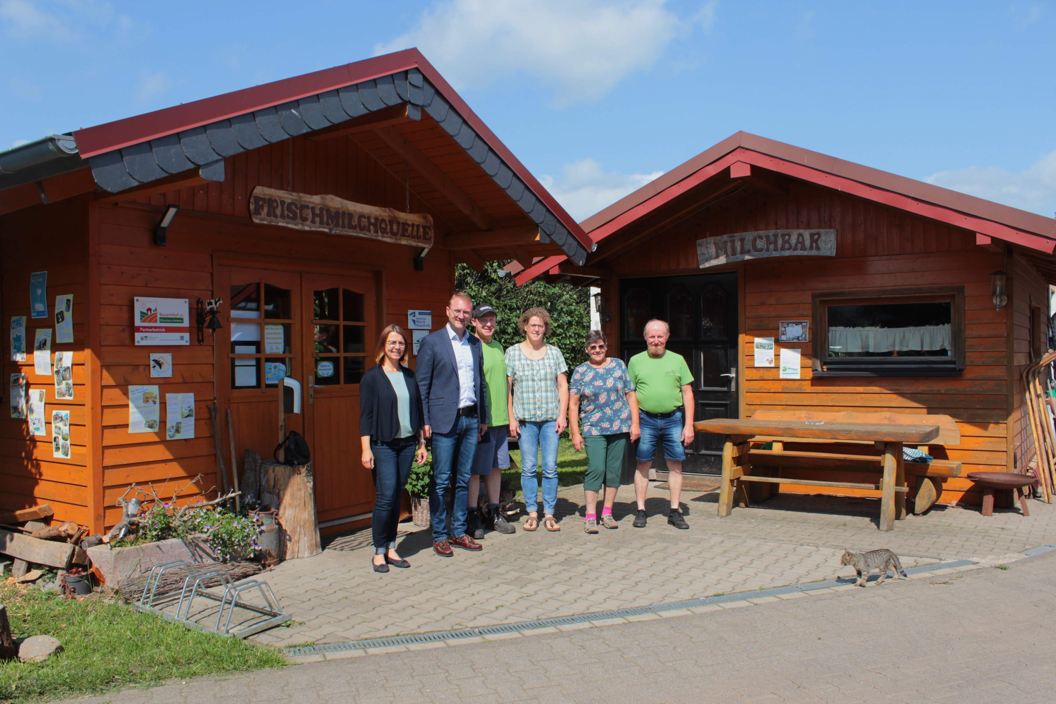 Gemeinsam mit dem Ersten Kreisbeigeordneten Dr. Jens Mischak (Zweiter von links) ist Anja Püchner, Leiterin des Amtes für Wirtschaft und den ländlichen Raum, zu Besuch auf dem Brückenwiesenhof. Klaus und Irmgard Löffler (von links) begrüßen die beiden gemeinsam mit Esther Waldeck und Andreas Löffler vor der Frischmilchtankstelle.