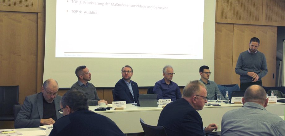Im Sitzungssaal des Vogelsbergkreises findet ein Workshop für das Radverkehrskonzept des Vogelsbergkreises statt. auf dem Foto sind einige Herren zu sehen, die einem Referenten zuhören