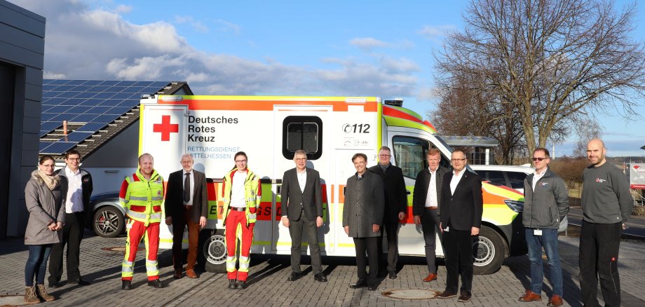 Zum Gruppenbild haben sich viele Menschen vor der Wache aufgestellt. Bei der offiziellen Inbetriebnahme (v.l.n.r.): Josi von Dietze (Betriebsrat RDMH), Marcel Greb (Bereichsleiter), Kevin Rühl (Einsatzdienst), Bernhard Ziegler (Bürgermeister Herbstein), Wiebke Rühl (Einsatzdienst), Manfred Görig (Landrat Vogelsbergkreis), Walter Ritz (Sparkasse Oberhessen), Alexander Schagerl (Volksbank Lauterbach-Schlitz), Jürgen Schad (Zentrale Leitstelle Vogelsbergkreis), Markus Müller (Geschäftsführer RDMH), Rainer Ruppert (Betriebsleiter RDMH), Jürgen Ritter (Gebäudemanagement RDMH). 