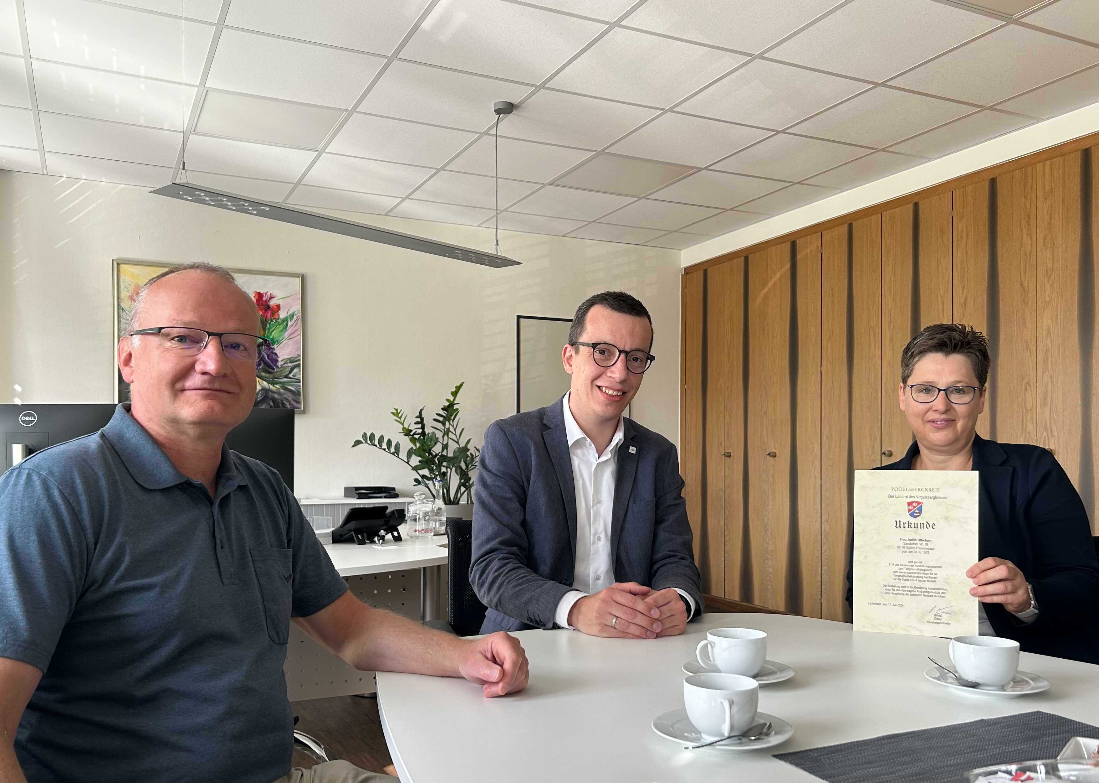 Erster Kreisbeigeordneter Patrick Krug (Mitte) ernennt gemeinsam mit Amtsarzt Dr. Robert Riße vom Veterinäramt (links) Judith Otterbein aus Fraurombach zur Bienensachverständigen. Nach drei Jahren in dieser Position wurde sie nun für weitere drei Jahre berufen.