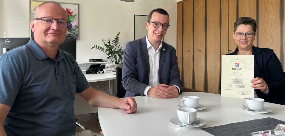 Erster Kreisbeigeordneter Patrick Krug (Mitte) ernennt gemeinsam mit Amtsarzt Dr. Robert Riße vom Veterinäramt (links) Judith Otterbein aus Fraurombach zur Bienensachverständigen. Nach drei Jahren in dieser Position wurde sie nun für weitere drei Jahre berufen.