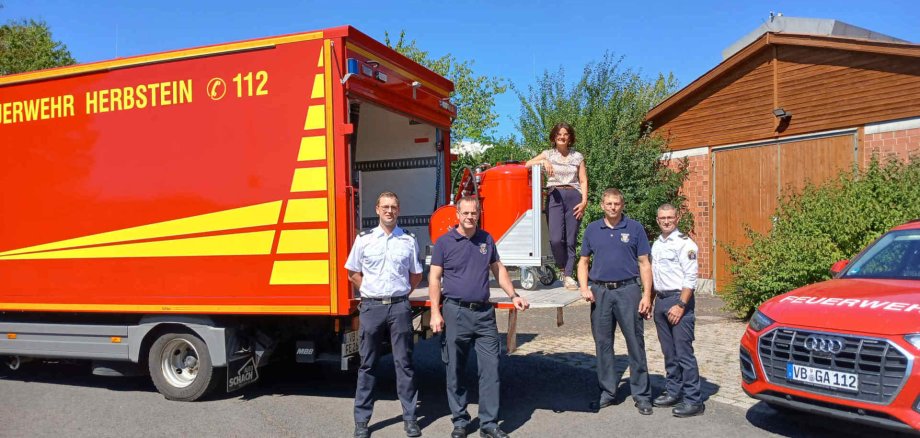 Holen den Rollcontainer Pulver am Katastrophenschutzzentrum des Vogelsbergkreises ab: Astrid Staubach, Bürgermeisterin der Stadt Herbstein, Bernhard Christen (zweiter von links), Stadtbrandinspektor der Stadt Herbstein, und Swen Jost (zweiter von rechts), Wehrführer der Herbsteiner Feuerwehr. Beschafft hat den Rollcontainer der Vogelsbergkreis, federführend dafür zuständig: Marcell Büttner (rechts), Kreisbrandinspektor und Leiter des Amtes für Gefahrenabwehr, und Sachbearbeiter Marc Filipp. 