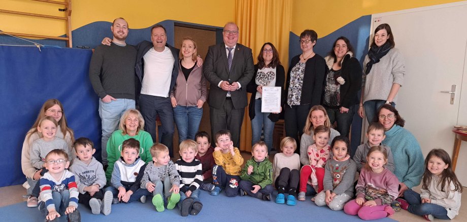 Freuen sich über die Auszeichnung (von links): Zahnarzt Luc Sayffaerth, der neu in die Praxis seines Vaters eingestiegen ist, Dr. Klaus Sayffaerth mit Tochter Kim Röther, die als Praxismitarbeiterin mit dem Vater die Kita als Patenschaftsteam betreut, Bürgermeister Stephan Paule, Kita-Leiterin Nicole Weitzel, Uta Born vom Arbeitskreis Jugendzahnpflege Vogelsberg, Dr. Sonja Schmidt-Schäfer, Schulzahnärztin im Gesundheitsamt, Carolin Rehm als Mitglied des Elternbeirates sowie Kinder und Mitarbeiter der Kita.